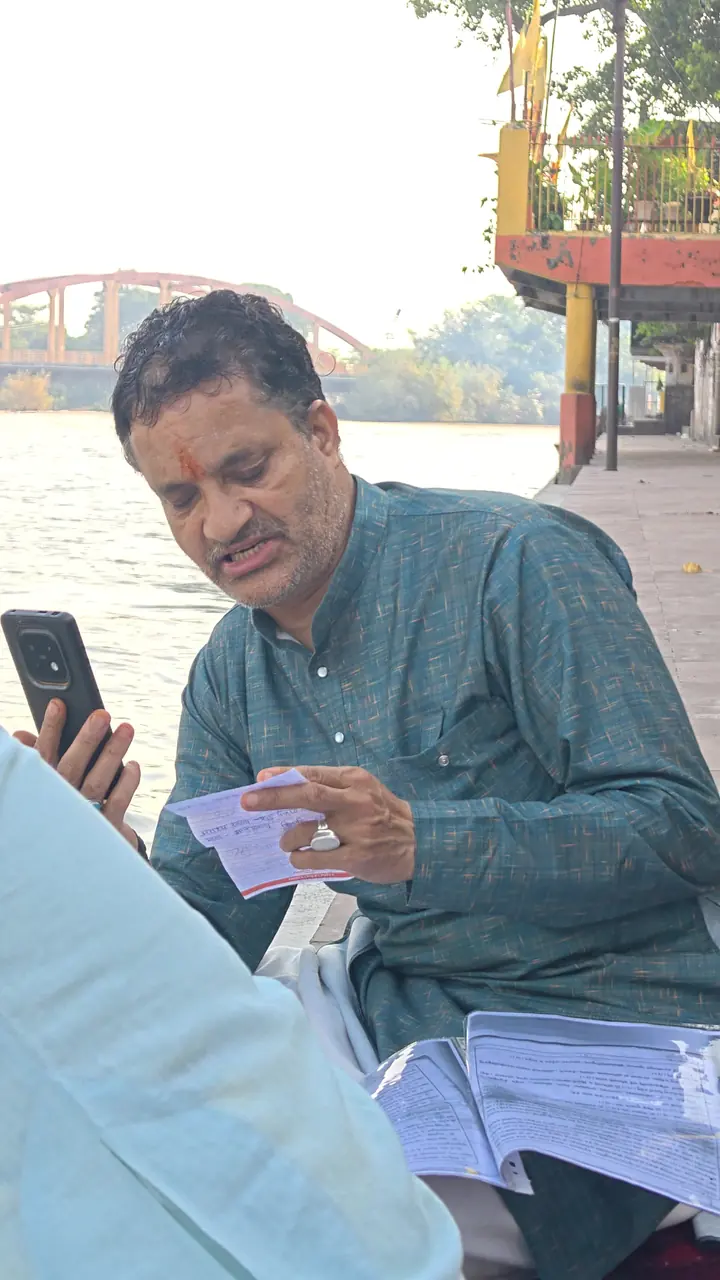 हरिद्वार के घाट पर, पीछे बहती गंगा के साथ, परिवार हेतु संकल्प एवं मंत्र पढ़ते गुरुजी। — पंडित गिरीश चंद्र परगाँई, हरिद्वार